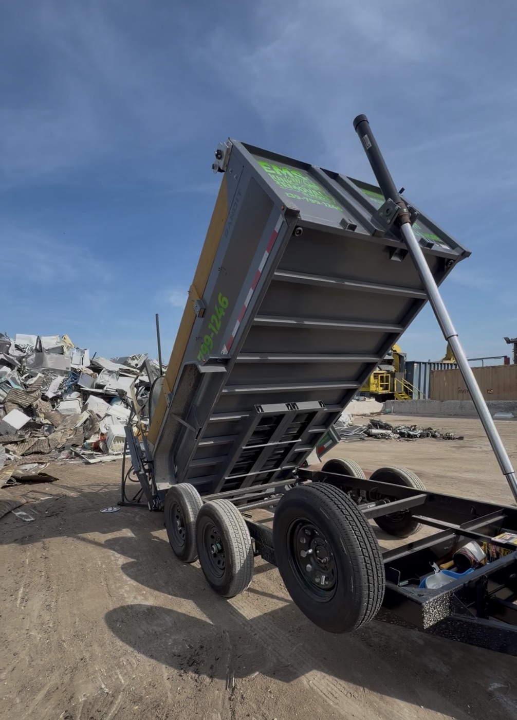 EMS dump trailer tilted up unloading debris at the disposal yard