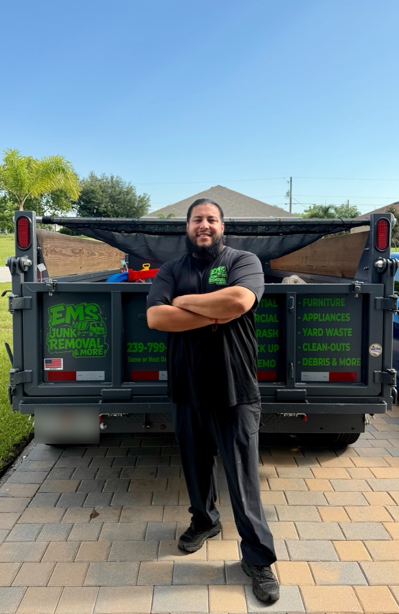 Erick Sabillon, owner of EMS Junk Removal & More, standing in front of the EMS dump trailer